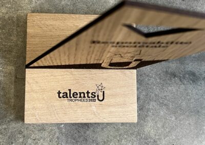 Gravure laser sur bois pour le trophée Talents U, mettant en valeur les détails du design